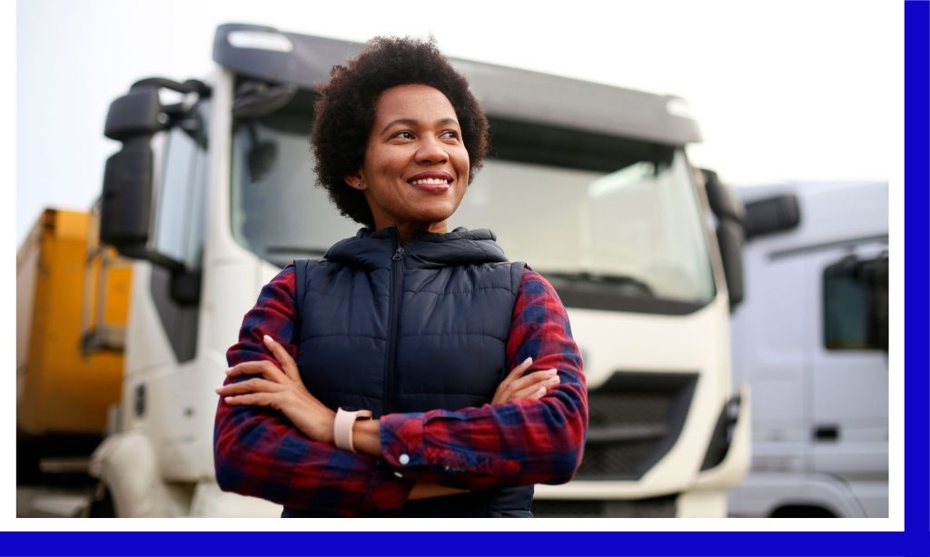 person smiling while standing in front of commercial trucks